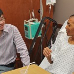 Hospice Patient Wang Qun Li Sitting in Hospital Bed Next to Son